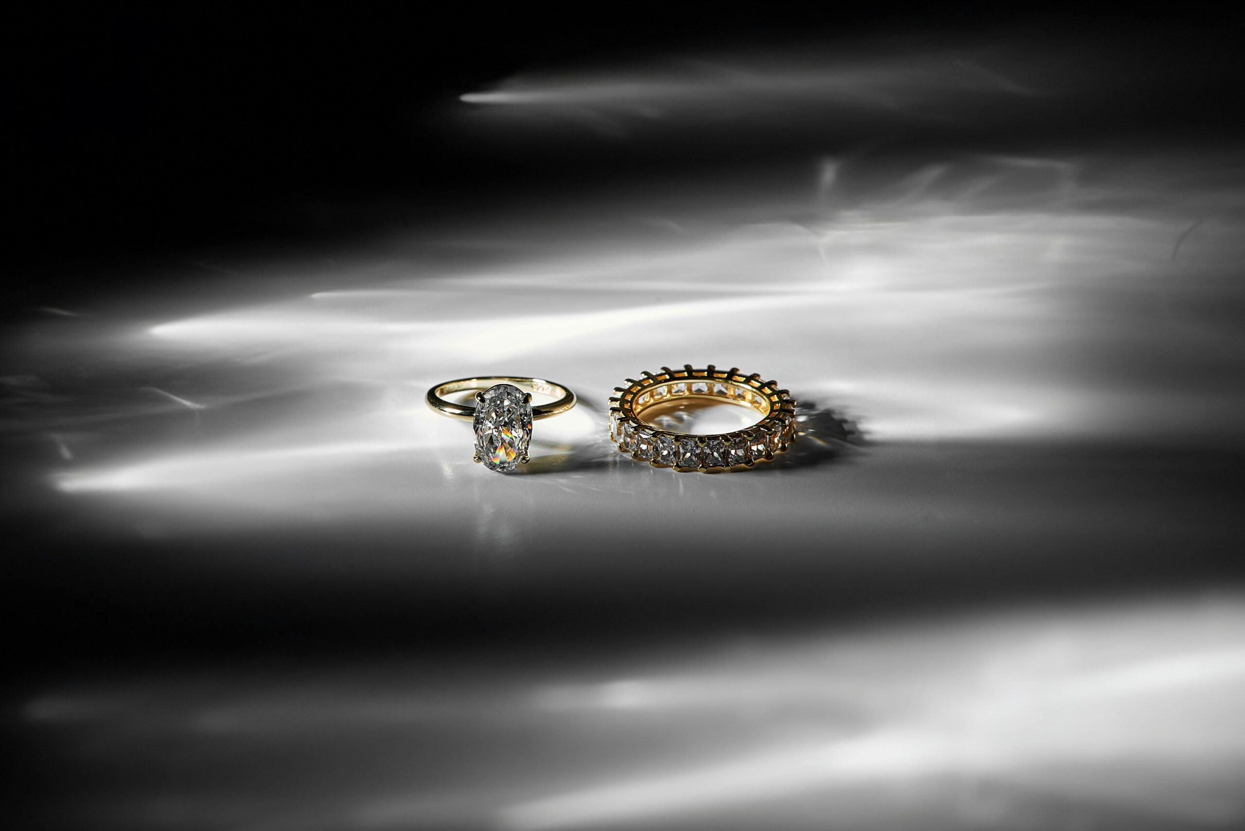 A stunning close-up of elegant gold and diamond rings on a reflective surface.